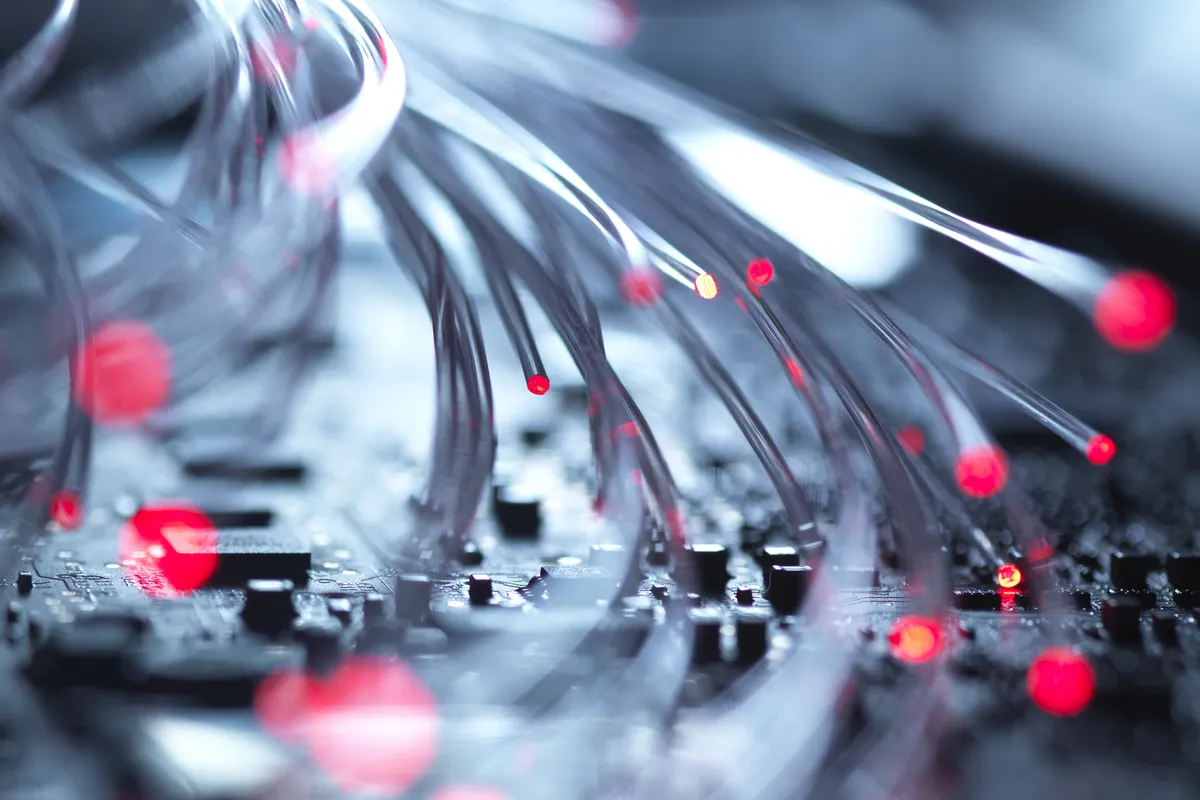 Close-up of fiber optic strands with glowing tips against a dark background