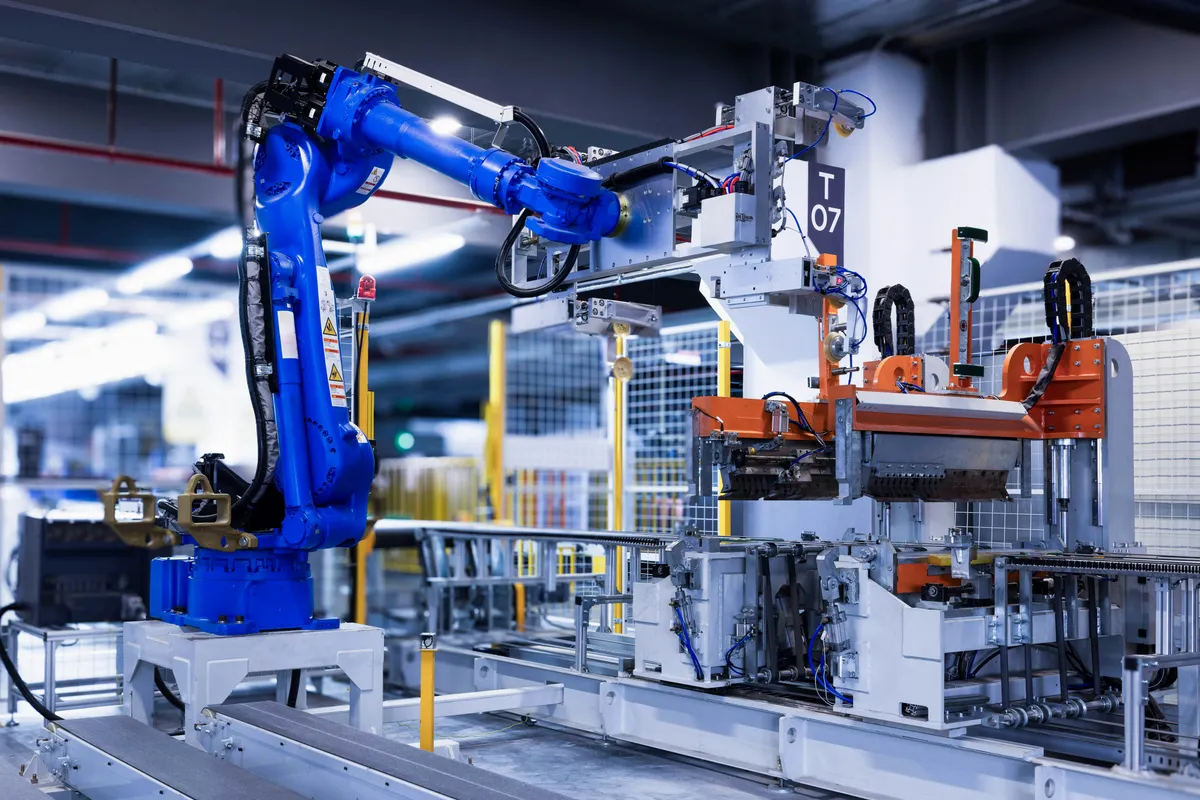 Blue industrial robot arm on a production line beside conveyor equipment